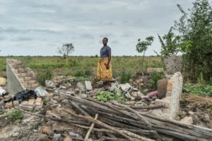 Maria Pedro, que sobreviveu ao ciclone Idai, em pé ao lado do que restou de sua casa