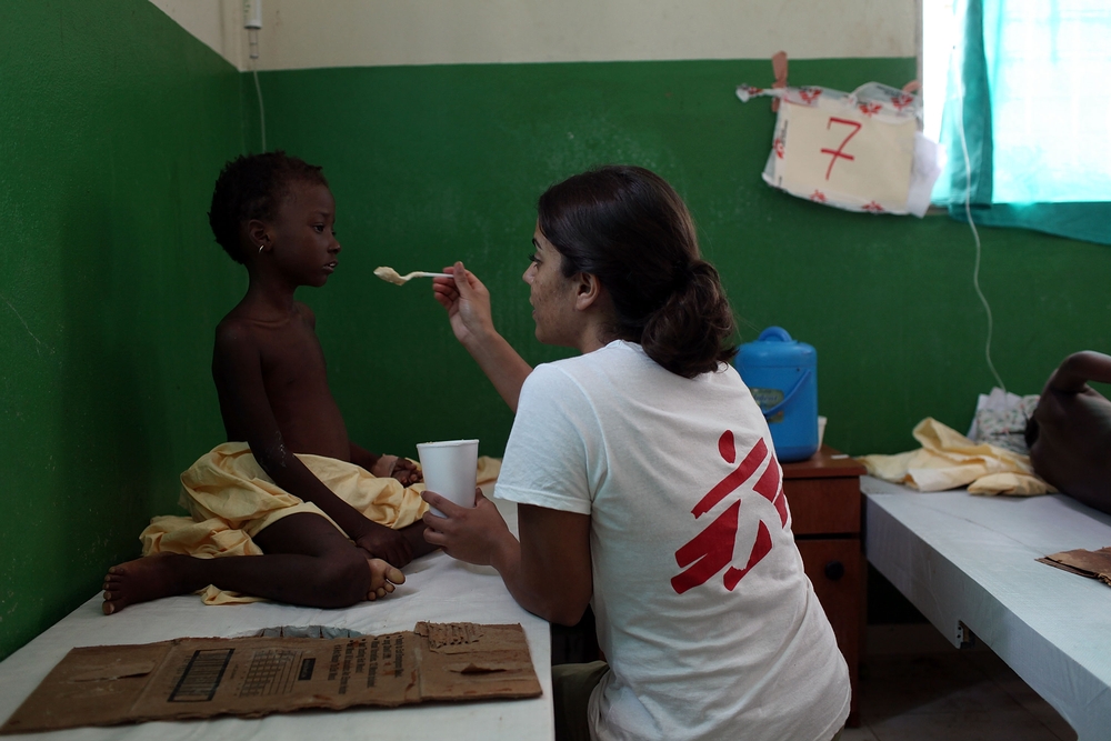 PETITE RIVIERE, HAITI - NOVEMBER 06: A doctor with Doctors Without Borders feeds a sick child with cholera in a clinic run by the Haitian government where Doctors Without Borders is treating cholera patients on November 6, 2010 in Petite Riviere, Haiti. According to the Haitian Health Ministry, the death toll from Haiti's cholera epidemic has now surpassed 500 dead with thousands being treated for the illness. Hurricane Tomas caused minor damage throughout the country and led to the evacuations of thousands of individuals from vulnerable tent camps to more secure structures. Over 1 million Haitians are refugees due to the January's earthquake. (Photo by Spencer Platt/Getty Images)