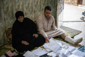 Hameeda e seu filho examinam seus arquivos médicos. Foto por: Chloe Sharrock / MSF