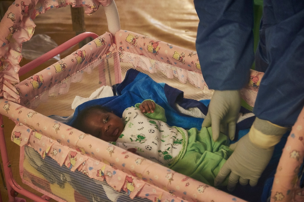 A bebê Nubia no centro de tratamento de Ebola de MSF em Nongo, em Conacri, na Guiné, em seu primeiro mês de vida. Apesar do começo triste – a morte de sua mãe após o parto, ocorrido enquanto estava doente de Ebola –, um ano depois Nubia faz de sua sobrevivência um final feliz para sua família e para quem se dedicou a sua recuperação.