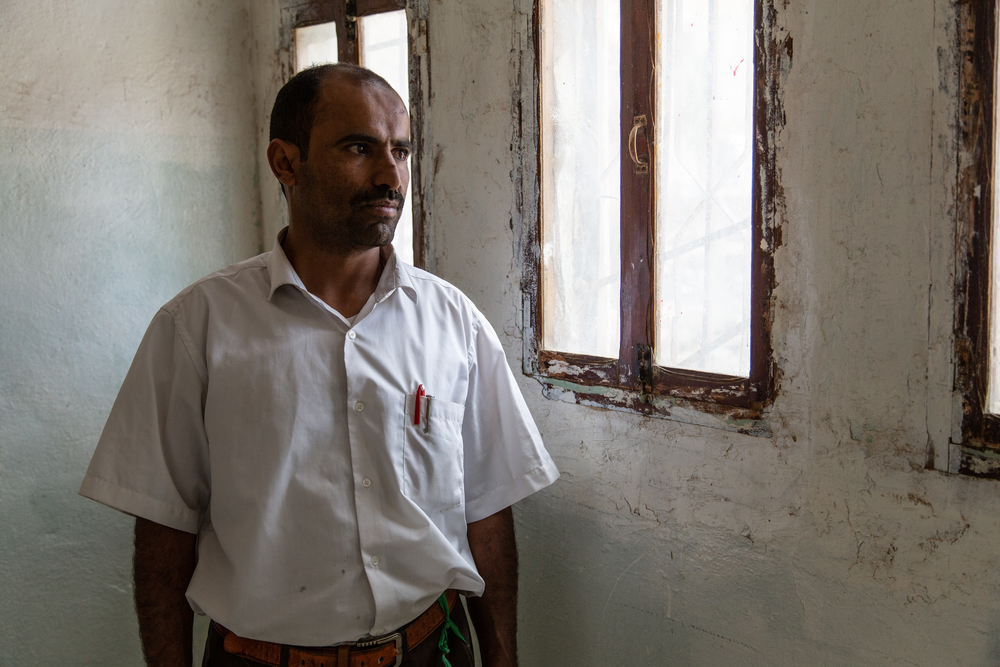 Sherif, de 33 anos, trabalha como vigia de MSF. Ele é de Sahar Al Sham, perto da fronteira saudita. Ele tem um filho de 6 anos. Sua família foi deslocada pela guerra, pois a região se tornou uma frente de batalha ativa. Ele costumava trabalhar como professor de inglês. A família mudou-se para Saada, onde trabalhou como mototáxi para ter dinheiro. Depois de um tempo, eles voltaram para Haydan, onde Sherif costumava trabalhar como professor voluntário. Com a guerra, a vida ficou difícil e os preços subiram vertiginosamente nos últimos anos. Ele está reclamando sobre o sistema escolar disfuncional: ele prefere ensinar seu filho em casa em vez de mandá-lo para a escola. Em Haydan, estudantes e professores têm medo de ir à escola desde que ela foi bombardeada pela coalizão saudita e pelos Emirados Árabes em 2015.