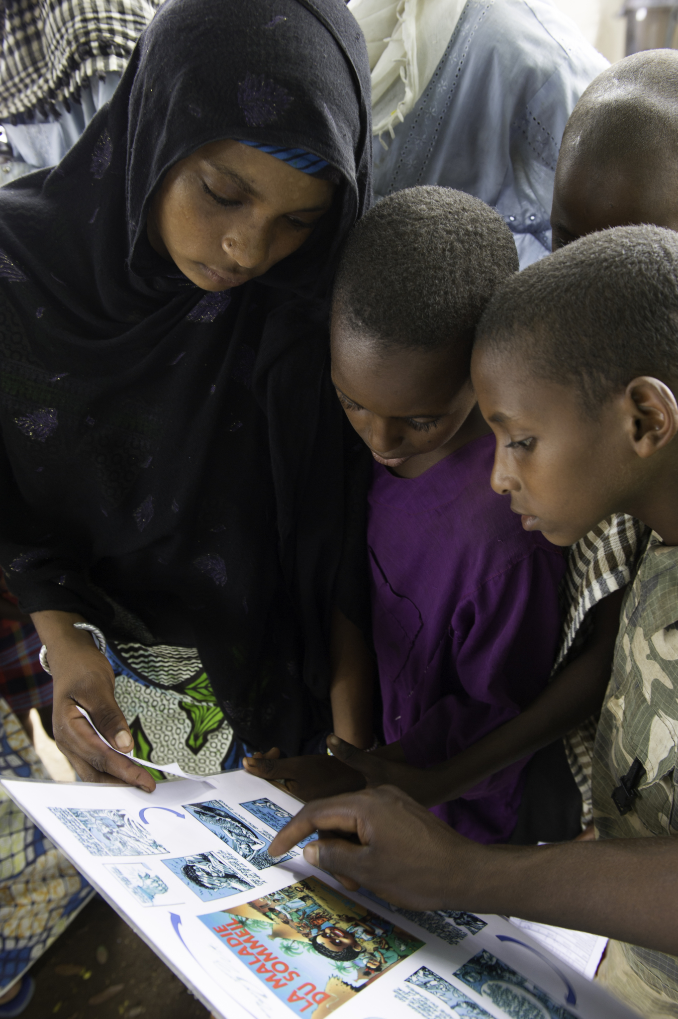 Crianças estudam o folheto informativo sobre a doença do sono na vila de Mboki, na República Centro-Africana. Elas estão se preparando para os testes que serão conduzidos pela equipe móvel de MSF.