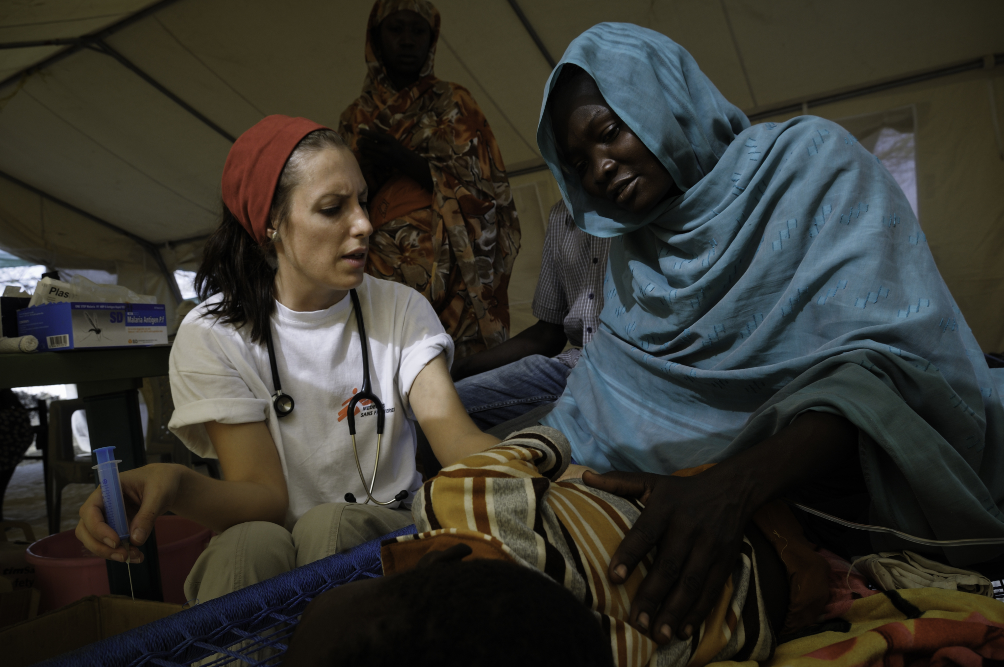 Kirrily atende Assosa Hamad e o filho Aman, que está com malária, na sala de emergência da clínica de MSF no campo da Jamam. Eles levaram três meses para chegar ao campo de refugiados, onde já estão há um mês e ainda dormem debaixo de uma árvore. "Tomamos água dos pântanos, embora não seja boa e nos provoque vômito e diarréia", diz Assosa.