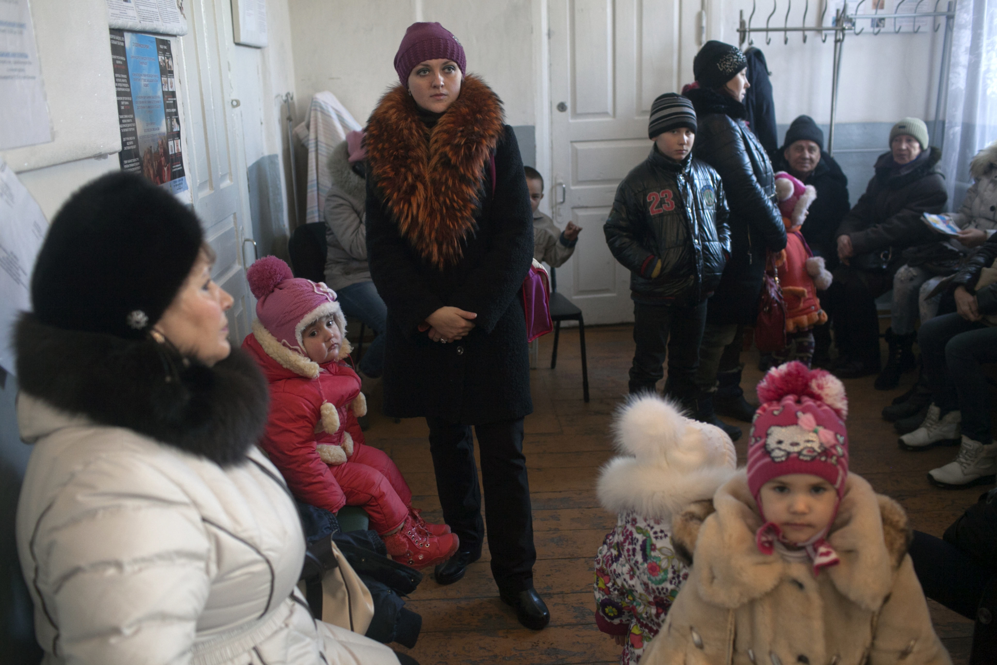 Pessoas lotam uma sala de espera na clínica móvel de MSF em Kuteynikovo. O médico do vilarejo foi transferido para outra cidade quando o conflito teve início e a comunidade está sem um médico regular há meses.