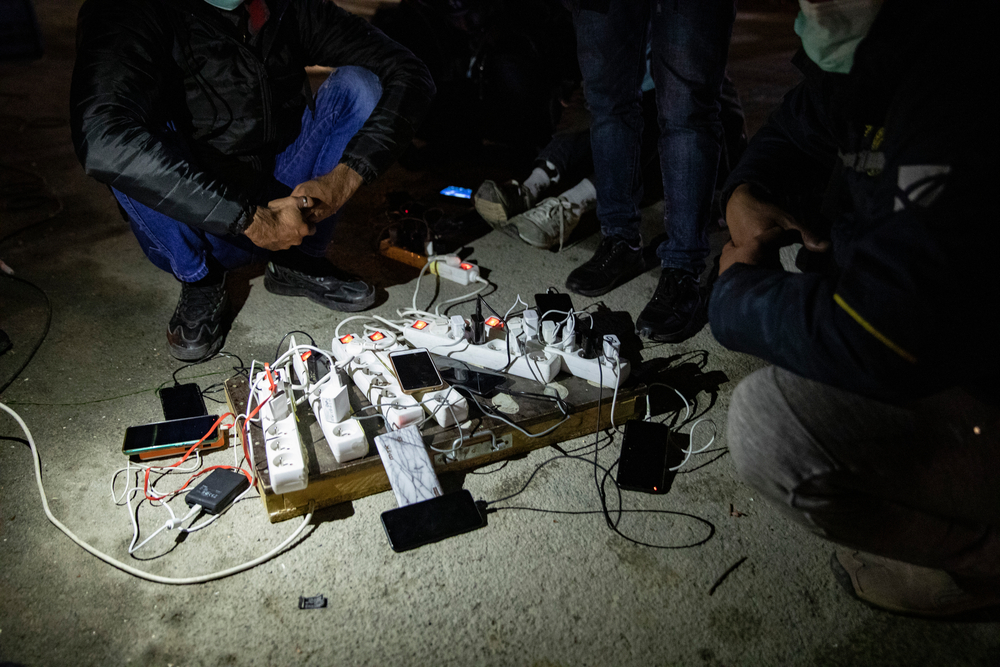 Pessoas carregam telefones e cabos de energia em um abrigo administrado por voluntários para migrantes que atravessam da Itália para a França. Turim, região do Piemonte, Itália, dezembro de 2020.