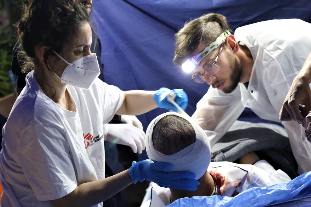 A equipe médica de MSF faz um curativo em um paciente palestino ferido pela polícia israelense durante confrontos em Jerusalém. Palestina, maio de 2021.