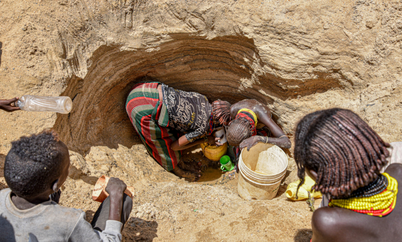 Mulheres buscam água em um poço      ao longo do leito de um rio seco em Illeret. A seca na região está forçando      pessoas a procurar fontes alternativas de água, que não são seguras para      consumo. Foto: Lucy Makori/MSF, Quênia, abril de 2022.