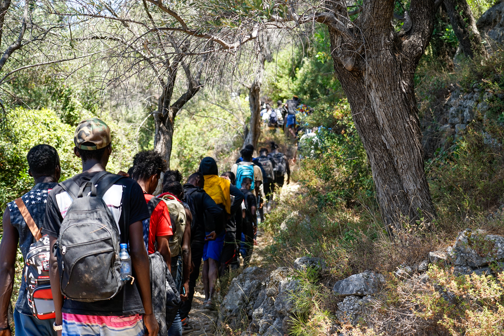 Pessoas que acabaram de chegar em Samos caminham por uma trilha rochosa após desembarcar. Equipes de MSF relataram altas necessidades médico-humanitárias entre os recém-chegados. Foto: Alice Gotheron/MSF, Grécia, julho de 2022.