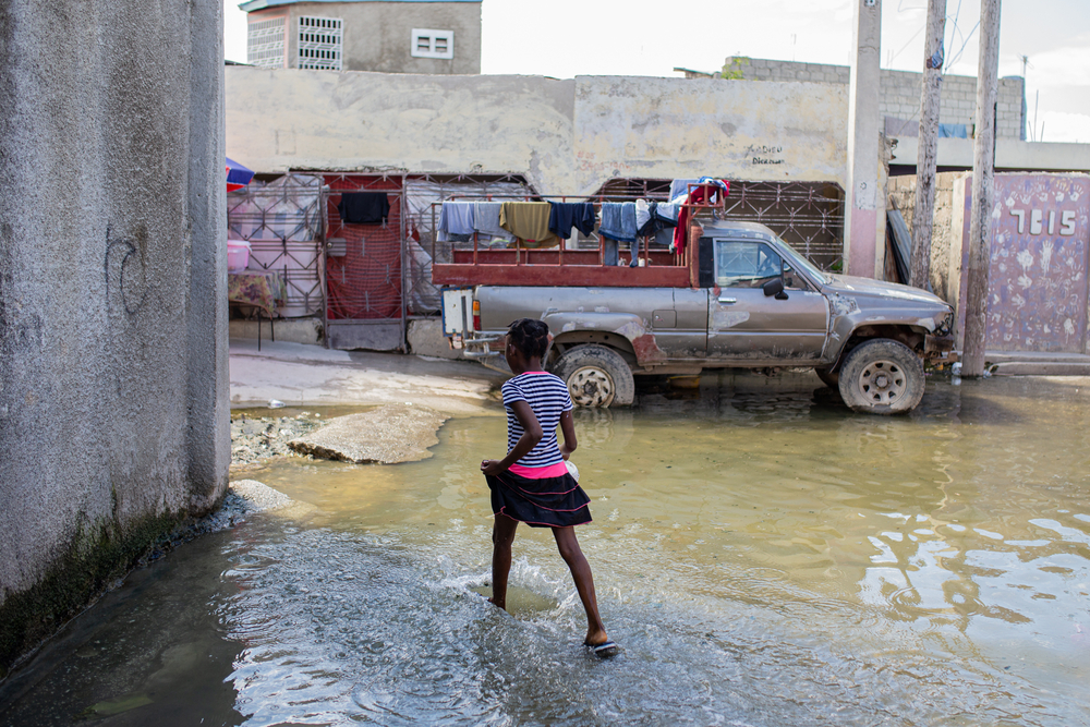 Uma criança passa por uma rua inundada no bairro de Cité l'Eternel. Lá, a cólera se espalha rapidamente devido ao saneamento precário e à falta de acesso a água potável.      Foto: Alexandre Marcou/MSF, Porto Príncipe, Haiti, outubro de 2022.