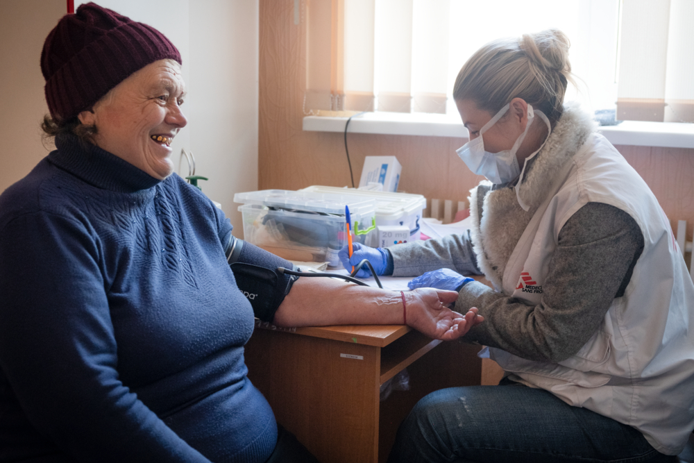 MSF doctor Olena Kurinna checking Anna Ivanivna Nefedova’s blood pressure in the Tsyrkuny village town hall, Kharkiv region. The ambulatory clinic of the village was destroyed in the fighting. Like Anna Ivanivna Nefedova, most patients MSF patients in the rural towns and villages of the Kharkiv region are babushkas, the Ukrainian older women and grandmothers. Many of them already living with disabilities such as limited mobility, loss of hearing or sight, caused by age or uncontrolled chronic illnesses, such as hypertension and diabetes, are at risk of complications. Uncontrolled hypertension can lead to serious complications such as loss of sight, kidney failure, neurological impairment or even sudden death. The lack of doctors, nurses, medicines augmented by stress factors caused by the war have made controlling these conditions difficult.