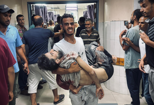Abdullah Hammad, que trabalhou com MSF em Gaza, é carregado para o hospital Nasser após ataque das forças israelenses contra pessoas que tentavam coletar alimentos dos caminhões de ajuda. Gaza, 3 de julho de 2025. ©Mohammad Salama