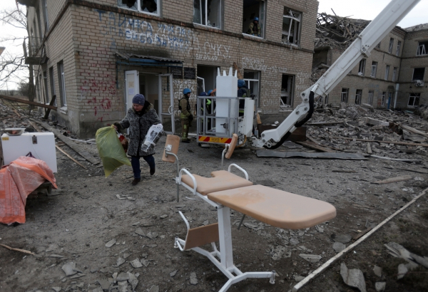 Funcionários do Serviço Estadual de Emergência da Ucrânia e equipe de saúde retiram equipamentos médicos de uma maternidade destruída por um ataque com mísseis russos na cidade de Selydove, na região de Donetsk. Ucrânia, fevereiro de 2024. ©Anatolii STEPANOV/AFP