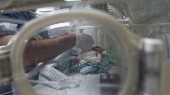 Profissional do Hospital Al-Helou, na Cidade de Gaza, examina um recém-nascido com baixo peso sob cuidados em uma incubadora. Abril de 2026. ©Nour Alsaqqa/MSF