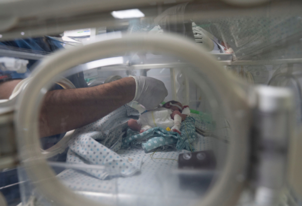 Profissional do Hospital Al-Helou, na Cidade de Gaza, examina um recém-nascido com baixo peso sob cuidados em uma incubadora. Abril de 2026. ©Nour Alsaqqa/MSF