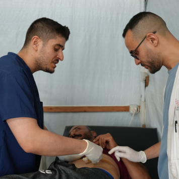 Equipe de Médicos Sem Fronteiras durante a troca de curativos nos ferimentos de um paciente. Gaza. Junho de 2026. ©Nour Alsaqqa/MSF