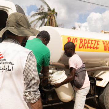 Lal Badshah,  técnico em abastecimento de água e saneamento de MSF, supervisiona o enchimento de um tanque de água de 200 litros na Paróquia de St. Elisabeth, Jamaica. Georg ©Gassauer/MSF