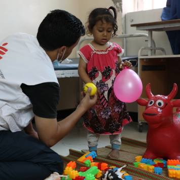 Amin Al-Badri, profissional saúde mental, brinca com Malak, de 3 anos de idade, diagnosticada com hemólise, no hospital materno-infantil de MSF em Houban. ©Nuha Haider/MSF