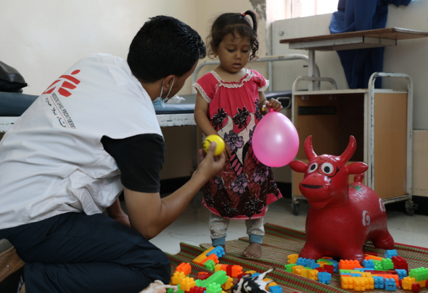Amin Al-Badri, profissional saúde mental, brinca com Malak, de 3 anos de idade, diagnosticada com hemólise, no hospital materno-infantil de MSF em Houban. ©Nuha Haider/MSF