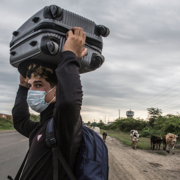 Um migrante venezuelano de 26 anos carrega seus pertences pela Rodovia Pan-Americana enquanto tenta chegar a Tumbes, no Peru. © Max Cabello Orcasitas