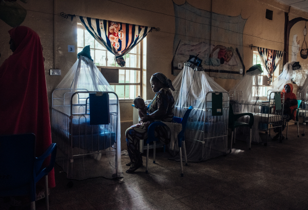 Amaka Joseph cuida de seu filho em recuperação no centro de nutrição terapêutica intensiva no Hospital Especializado de Sokoto, Nigéria. © KC NWAKALOR