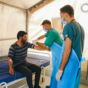 Profissional de saúde examinando um paciente com cólera na unidade de tratamento de cólera apoiada por MSF em Idlib, no noroeste da Síria. © Abd Almajed Alkarh/MSF