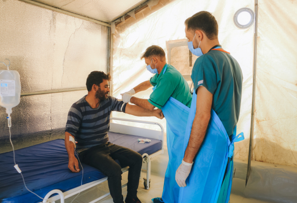 Profissional de saúde examinando um paciente com cólera na unidade de tratamento de cólera apoiada por MSF em Idlib, no noroeste da Síria. © Abd Almajed Alkarh/MSF