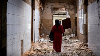 Echa, promotora de saúde mental de MSF que também sofreu violência durante o conflito em Cabo Delgado, caminha pelas alas destruídas do hospital geral de Mocímboa da Praia, no norte de Moçambique. © Nuria Lopez Torres/MSF