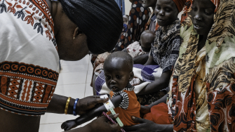 Profissional de saúde realiza um exame de desnutrição em Alnel, uma criança de 1 ano de idade, acompanhada de sua mãe, Nyanbeny. ©Sean Sutton/Panos Pictures