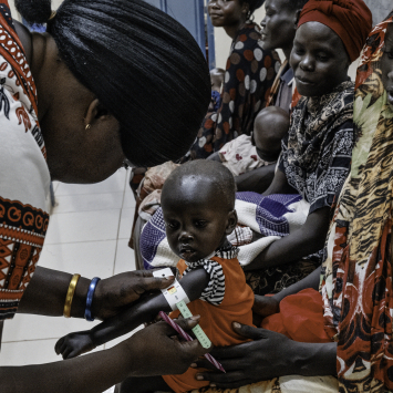 Profissional de saúde realiza um exame de desnutrição em Alnel, uma criança de 1 ano de idade, acompanhada de sua mãe, Nyanbeny. ©Sean Sutton/Panos Pictures