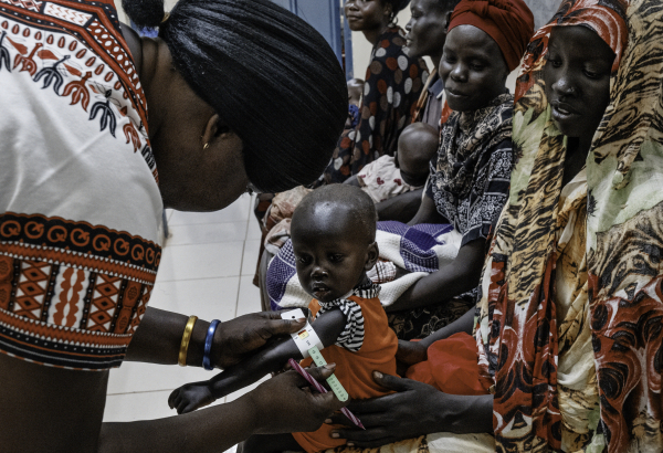 Profissional de saúde realiza um exame de desnutrição em Alnel, uma criança de 1 ano de idade, acompanhada de sua mãe, Nyanbeny. ©Sean Sutton/Panos Pictures