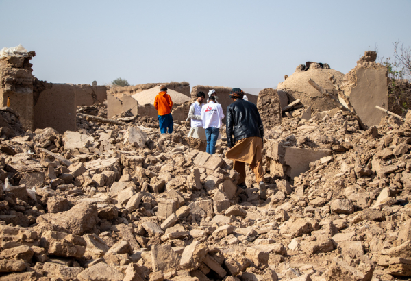 Equipe de MSF caminhando sobre os escombros de casas no vilarejo de Sanjaib, distrito de Injil, província de Herat. © Paul Odongo/MSF