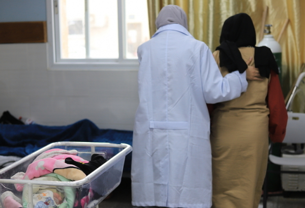 Profissional de saúde auxilia paciente no hospital Emirati, em Gaza. Janeiro de 2024. © Mariam Abu Dagga/MSF