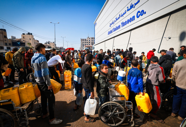 Um grupo de palestinos deslocados espera pela distribuição de água de MSF na área de Tal Al-Sultan, na cidade de Rafah, sul de Gaza. Janeiro de 2024. © MSF