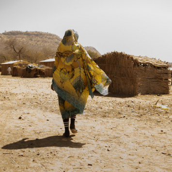 Awa Ousman Abdelkarim caminhando pelo acampamento de Daguessa, no leste do Chade. Ela é uma refugiada sudanesa que vive no local com parte de sua família. © Giuseppe La Rosa/MSF