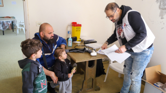 Ali e Elias acompanham o pai em uma consulta na unidade médica móvel de MSF em Al Merouaniye. Os dois irmãos estão entre as muitas crianças que se abrigam com suas famílias no Hotel Montana. © Maryam Srour/MSF