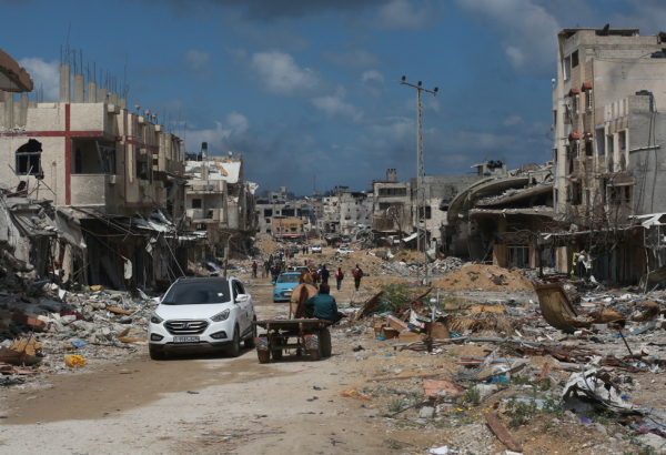 Pessoas deslocadas caminham entre prédios destruídos pela violência implacável e pelos bombardeios em Gaza. Palestina, 6 de maio de 2024. © MSF