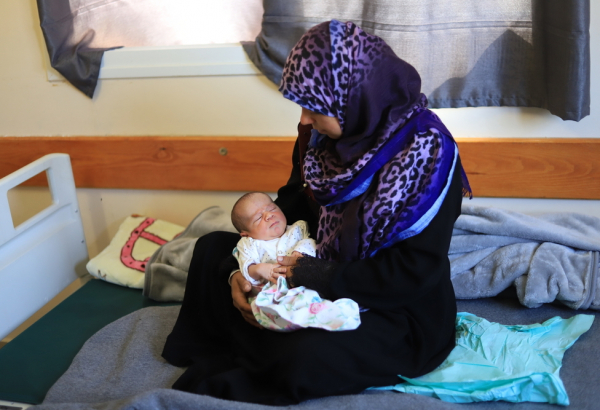 Khadra, que deu à luz no hospital Nasser, no sul de Gaza, com seu bebê. © Mariam Abu Dagga/MSF