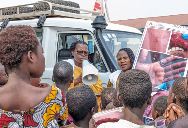 Equipe de promoção de saúde compartilhando informações sobre mpox em acampamento de pessoas deslocadas na RDC. ©Augustin Mudiayi/MSF