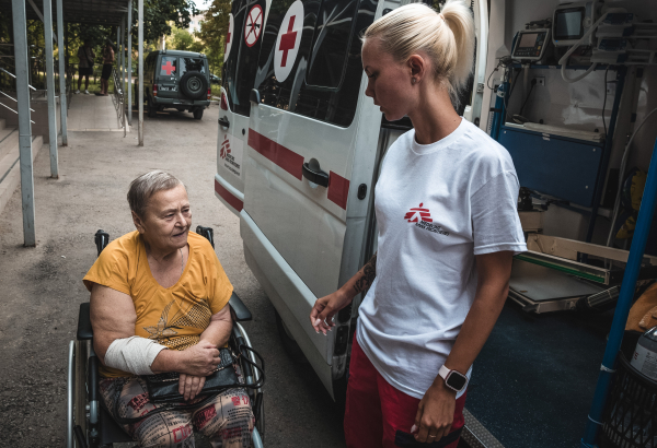 Profissional de MSF ajuda paciente a entrar em ambulância. Agosto de 2024 ©️ Olexandr Glyadyelov