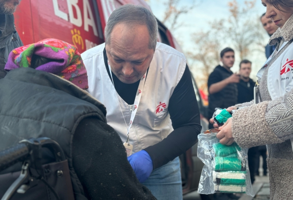 Oleksandr Hontariev, médico de MSF, realiza um tratamento inicial no braço de um paciente perto do centro de trânsito em Pavlohrad, região de Dnipropetrovsk. Ucrânia, novembro de 2024. © Yuliia Trofimova/MSF