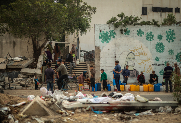 Na Al Jalaa Street, na Cidade de Gaza, as pessoas fazem fila para pegar água. © Motassem Abu Aser
