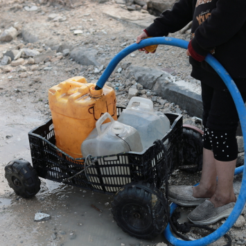 Palestinian child is collecting water in Beit Lahia city, north of Gaza strip, Palestine.