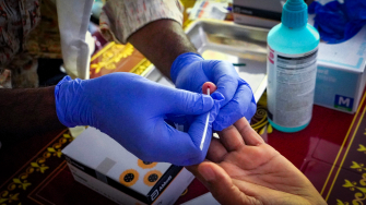 Profissional de MSF coleta amostra de sangue de paciente para teste de hepatite C. Bangladesh, 2025 © Tania Sultana/MSF