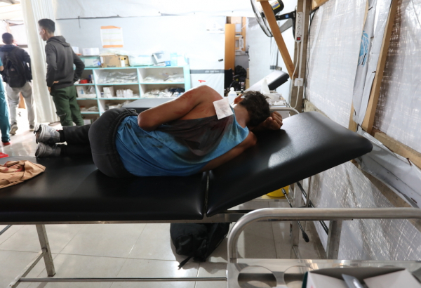 Ashraf, de 17 anos, recebe tratamento na clínica Al-Mawasi após ser baleado enquanto tentava buscar alimentos em um local de distribuição apoiado pelos EUA e por Israel em Gaza. Palestina, junho de 2025. ©Nour Alsaqqa/MSF