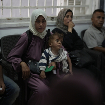 Donia Alouf e seu filho Ahmed, de 1 ano de idade, diagnosticado com desnutrição. Donia recebe assistência médica na clínica de Gaza, na Cidade de Gaza. Ela está grávida de 8 meses e também está com desnutrição. ©Nour Alsaqqa/MSF