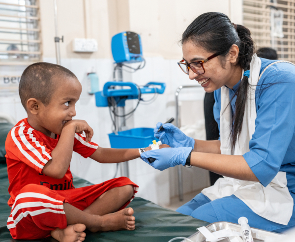 Shofi Mohammad, de 4 anos, se prepara para uma cirurgia no hospital de MSF em Kutupalong, com o apoio da enfermeira Zannatul Arafat. Bangladesh, maio de 2025. ©Ante Bussmann/MSF