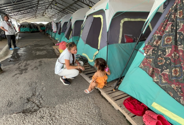 Profissional de MSF conversa com criança em um abrigo na cidade de Matamoros, no México. Junho de 2025.  © Christian Zetina/MSF