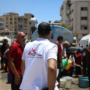 Mahmoud Abu Nada, coordenador de logística de MSF, durante distribuição de água na cidade de Gaza. ©Nour Alsaqqa/MSF