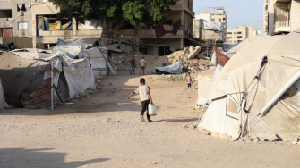 Menino palestino carrega galão de água para a tenda de sua família deslocada, em meio à crise hídrica provocada por Israel em Gaza. ©MSF
