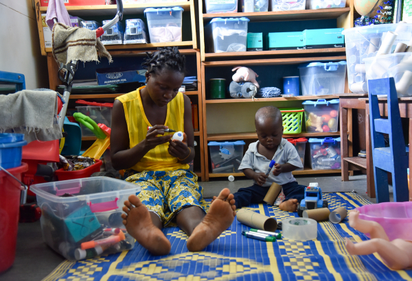 Morrison Williams, de 1 ano, e sua mãe, Adama, participam de uma sessão de brincadeira no Hospital Materno-Infantil de MSF em Kenema, Serra Leoa. ©Mary Dumbuya/MSF
